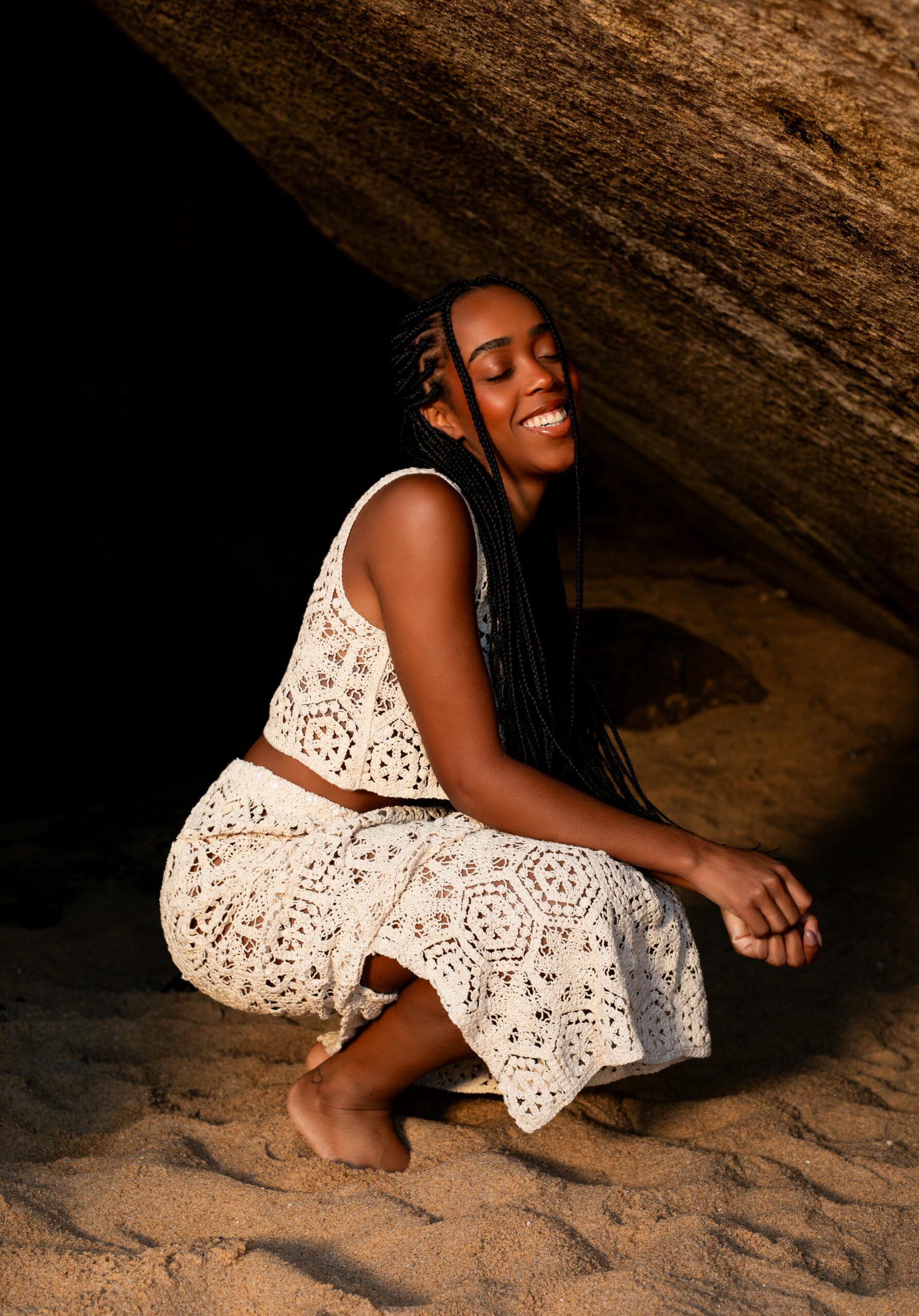 Smiling woman in a crochet dress enjoying a moment at the beach in Blumenau, Brazil.